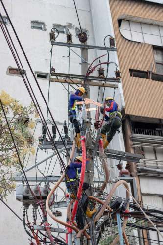 surabaya three people climbing on electric post indonesia